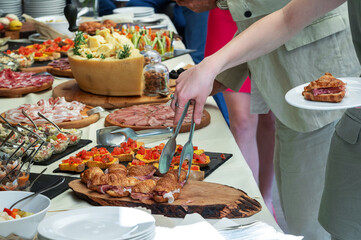 Fototapeta premium Unrecognizable person hand taking food from catering table