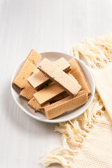Chocolate flavored wafers on a white plate with a cup of tea in the background. with copy space. perfect for recipe, article, catalogue, or any commercial purposes.