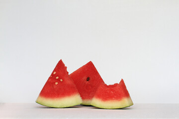 Three slices of watermelon (Citrullus lanatus) on white background.