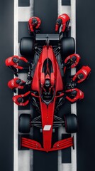 Fototapeta premium Formula 1 race car being serviced by team of mechanics in red uniforms, with the car raised on jacks and the mechanics working on different parts of the vehicle.