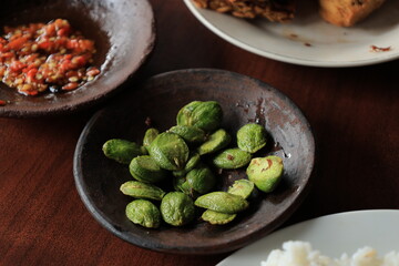 Lalapan or fresh raw vegetables basket with Pete (petai), chili sauce or sambal