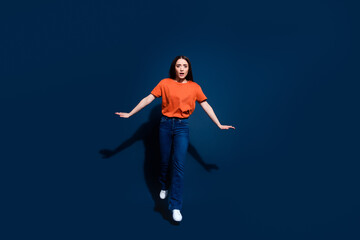 Fototapeta premium Photo of anxious embarrassed woman wear orange trendy clothes go empty space isolated on dark blue color background