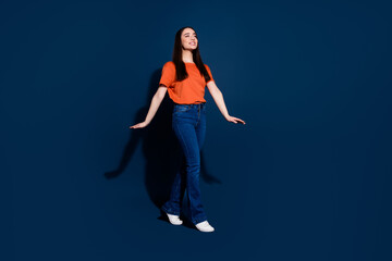 Photo of excited pretty cute woman wear orange stylish clothes look empty space isolated on dark blue color background