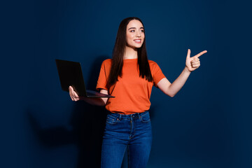 Photo of charming pretty woman wear orange stylish clothes demonstrate empty space isolated on dark blue color background