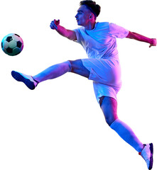 Young athletic man, football player, dressed in red and white uniform, performs high kick, focusing on controlling ball with precision against transparent background. Concept of championship, game