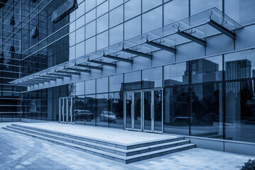 Modern Glass Building Entrance with Reflective Facade and Steps