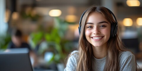 young woman in a call center, wearing a headset with mic, smiling and engaging in customer service and CRM, telemarketing and client support, providing help desk solutions with mockup space
