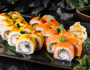 Sushi rolls set served on black plate with wasabi and ginger