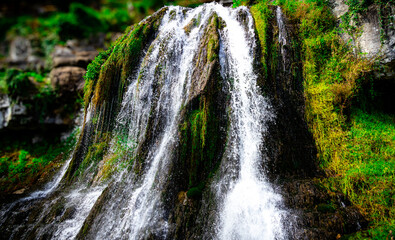 Serene Waterfall Cascading Over Lush Green Landscape