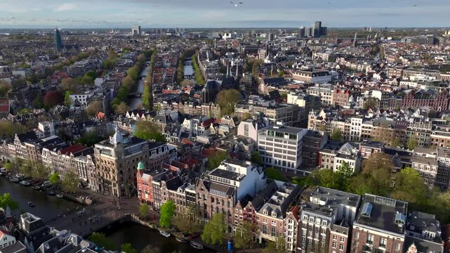Historical Center of Amsterdam, Netherlands. Aerial Drone Shot of Traditional Dutch houses on narrow street and channel.