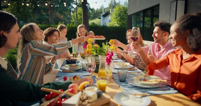 Big Family and Friends Celebrating Outside at Home. Diverse Group of Children, Adults and Old People Gathered at a Table, Having Fun Conversations. Making Toasts in the Backyard while Drinking Wine