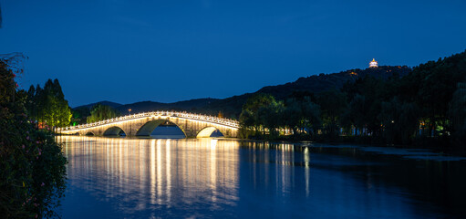 Serene Nighttime Reflection of Illuminated Bridge Over Calm Waters