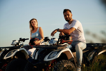 Rest time, sitting and taking a break. Man and woman are on ATV outdoors