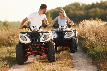 On the open rural road. Man and woman are on ATV outdoors