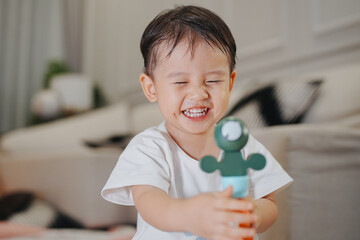 Happy child playing with a toy in a cozy living room, expressing joy and innocence. Perfect capture...
