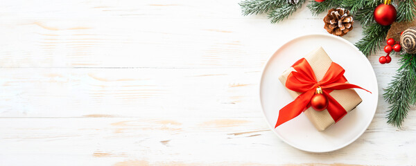 Christmas table with holiday food background. White plate and decorations top view. Long format.