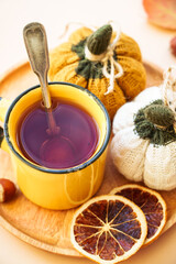 Cup of tea, spices, and knitted pumpkins. Cozy autumn composition, home decor.