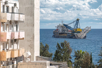 Offshore construction vessel installing subsea pipeline near residential area. Limassol, Cyprus