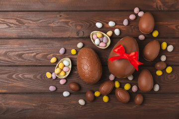 Easter chocolate egg on textured background. Easter celebration concept. Easter chocolate rabbit. Chocolate sweet eggs. Candies on textured wooden table. Space for text.Copy space. Gift. Banner.