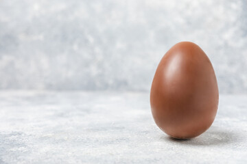 Easter chocolate egg on textured background. Easter celebration concept. Easter chocolate rabbit. Chocolate sweet eggs. Candies on textured wooden table. Space for text.Copy space. Gift. Banner.