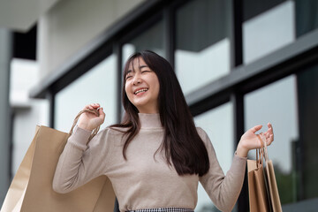 Joyful Woman Enjoying a Shopping Spree with Multiple Bags in a Modern Urban Setting