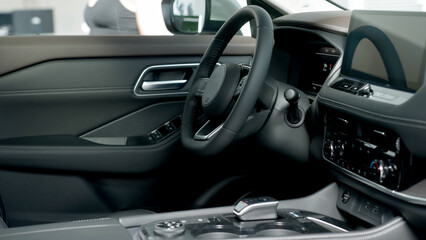 A close-up of a modern car's steering wheel showcases its sleek design and advanced features. This detailed view emphasizes the craftsmanship and innovation that enhance the driving experience.