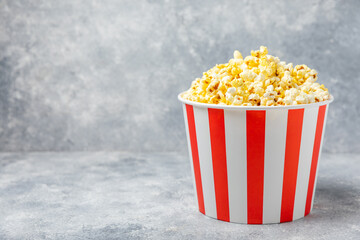 Salty popcorn on bright color background. Cinema and entertainment concept. Movie night with...