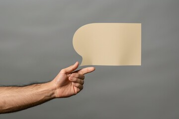 Hand with yellow adhesive note on gray background