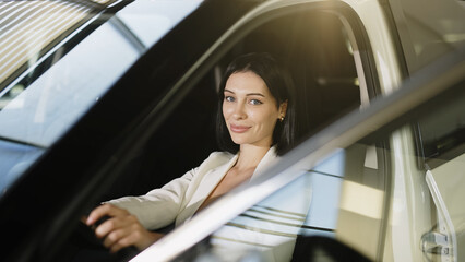 A businesswoman sits confidently in her car, exuding professionalism and style. This moment captures the essence of modern mobility, reflecting her dynamic lifestyle and the freedom of driving.