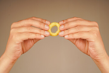 Onion ring. Deep fried onion rings. Snack for beer. Fast food. Junk food. Cooked tasty appetizer meal. Fried rings. Corn onion rings. Unhealthy food. Eating onion rings. Man holds onion ring.