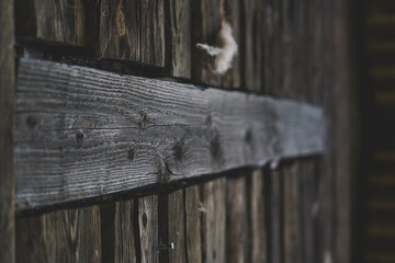 A dark wooden wall. A wooden board across other boards. Wooden background