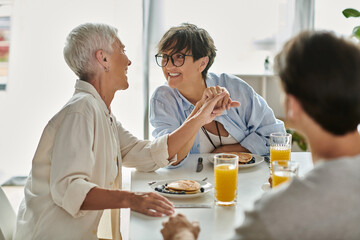 A warm breakfast shared among a loving LGBTQ family enjoying laughter and connection.