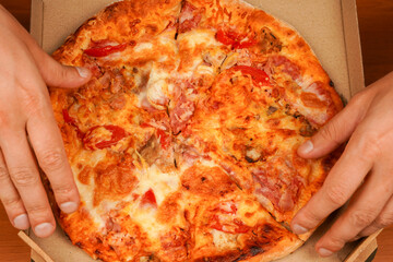Hand taking pizza slice, close up view. Tasty food at pizzeria. Concept of takeaway. Fast food order. Restaurant advertising. Delicious cheesy pizza. Pizza. Unhealthy food. Junk food. Fatty food.