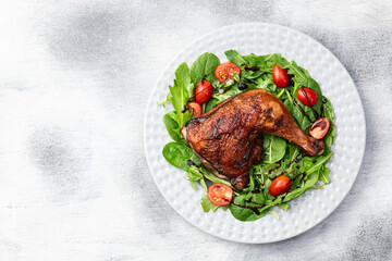 Grilled chicken legs with tomatoes and salad . Top view