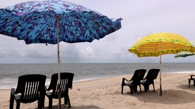 Colorful umbrellas and chairs set up for tourists at Marari Beach at Alappuzha, Kerala, India