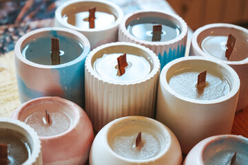 Manufacture and production of scented candles. Craft wax candle. Process of pouring melted coconut wax and placing the wick in candle jars.