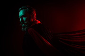 Photo of mysterious retired man evil wizard turn around back cape halloween costume isolated dark...