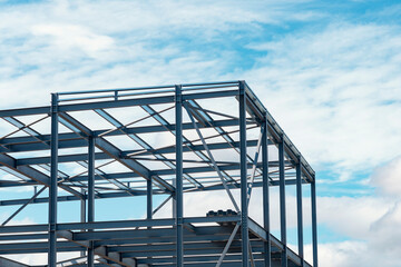 Steel framework reaches for the skies on clear day at  bustling construction site