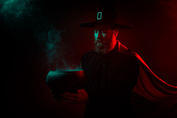 Photo of mysterious serious retired man brew evil potion hold cauldron isolated dark red green neon...