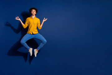 Fototapeta premium Full size photo of nice young man jump meditate isolated on dark blue color background