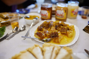 People sit at the table and eat honey, cake and drink honey drink.