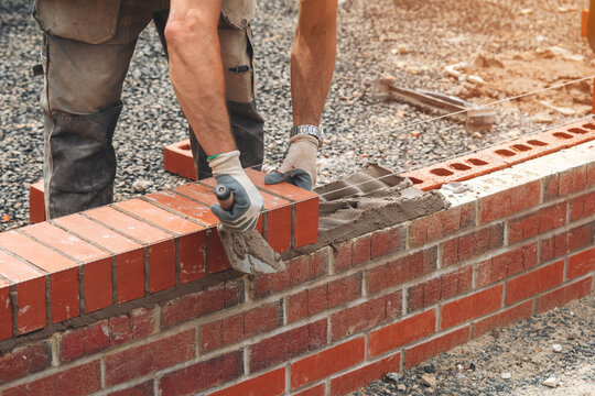 Crafting sturdy brick wall on construction site with skilled hands in the warm afternoon light