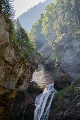 Scenic waterfall cascading down rocky cliffs in a lush mountain forest