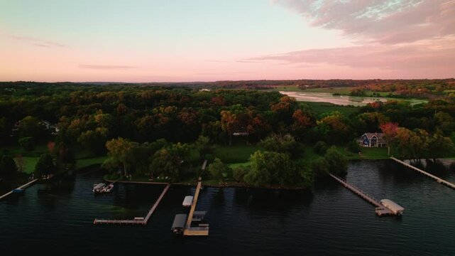 Aerial view during dusk over houses near the water at Green Lake Inlet Boat Launch Site in Ripon, Wisconsin. Serene residential living by the lake as day transitions into night.