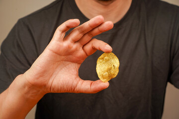 Unhealthy lifestyle. Man eating potato chips. Fast food. Junk food. Hands hold potato chip....