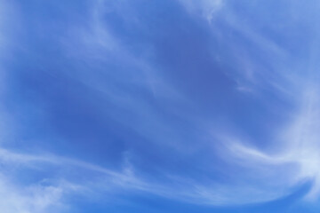 Fototapeta premium A beautiful blue sky with soft, wispy clouds creating a serene atmosphere. Perfect for backgrounds, nature themes, and calming visuals.