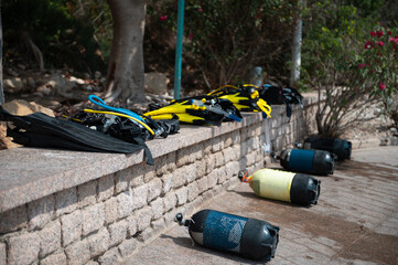 Scuba diving equipment lined up by the beach on a sunny day