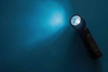 Flashlight casting a blue light against a dark wall in a dimly lit environment