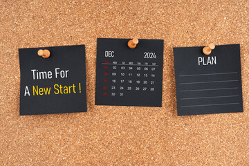December 2024 calendar with Time for a new start and Plan text on black adhesive notes.