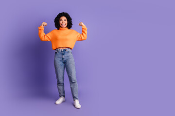 Full length photo of adorable lovely girl wear orange jumper showing muscles empty space isolated violet color background